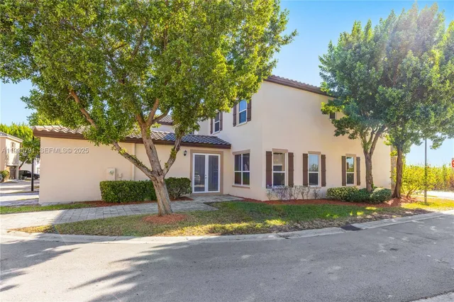 a front view of a house with a yard and trees