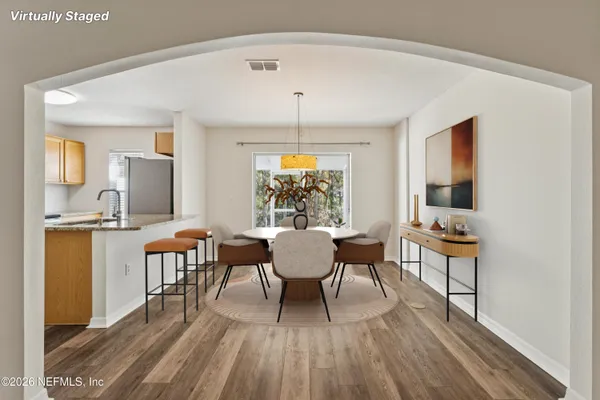 a dining room with furniture a rug and wooden floor