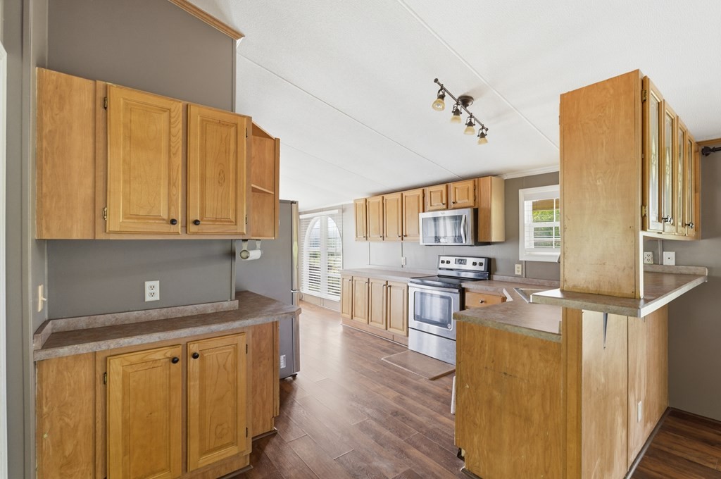 611 Farmer Road Walling, TN 38587 - Photo 11 of 27 a kitchen with stainless steel appliances granite countertop a stove a sink dishwasher and a refrigerator with wooden floor