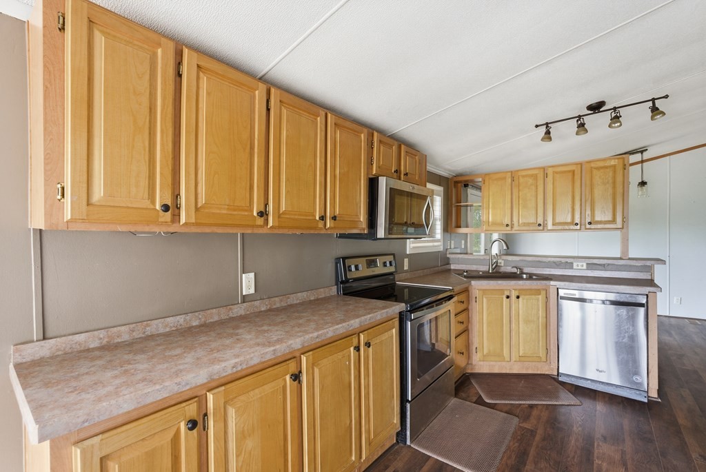 611 Farmer Road Walling, TN 38587 - Photo 12 of 27 a kitchen with stainless steel appliances granite countertop a stove a sink dishwasher and a microwave oven with wooden floor