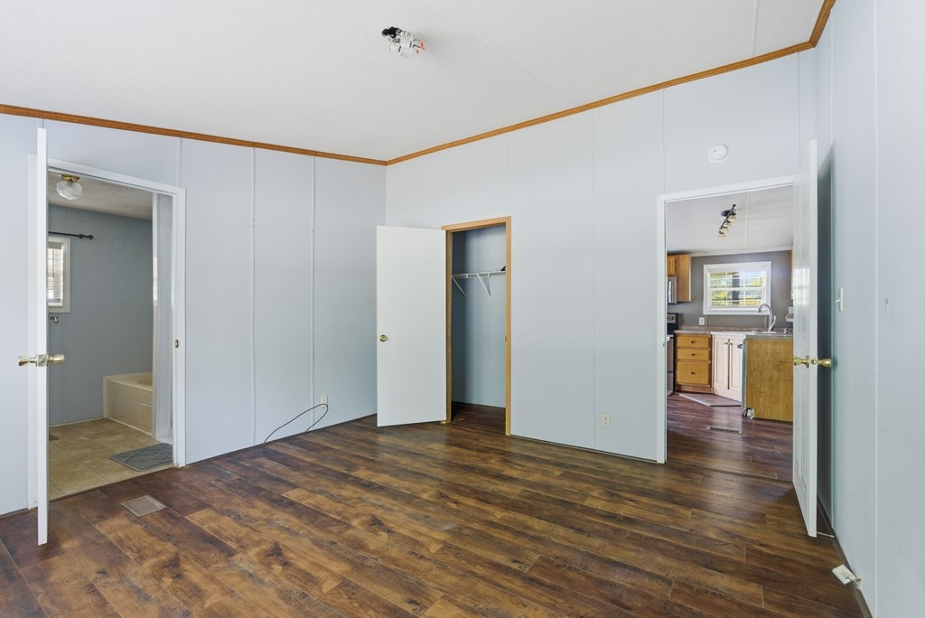 611 Farmer Road Walling, TN 38587 - Photo 16 of 27 a view of a big room with wooden floor and a kitchen view