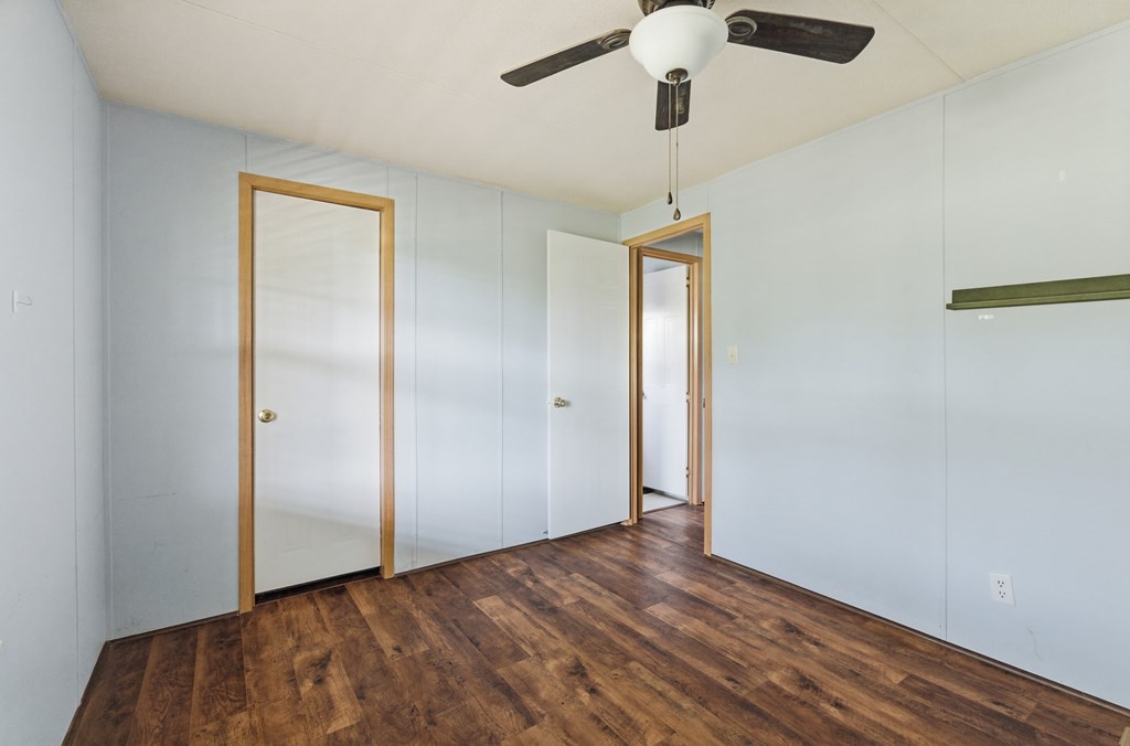 611 Farmer Road Walling, TN 38587 - Photo 19 of 27 wooden floor in an empty room with a chandelier fan