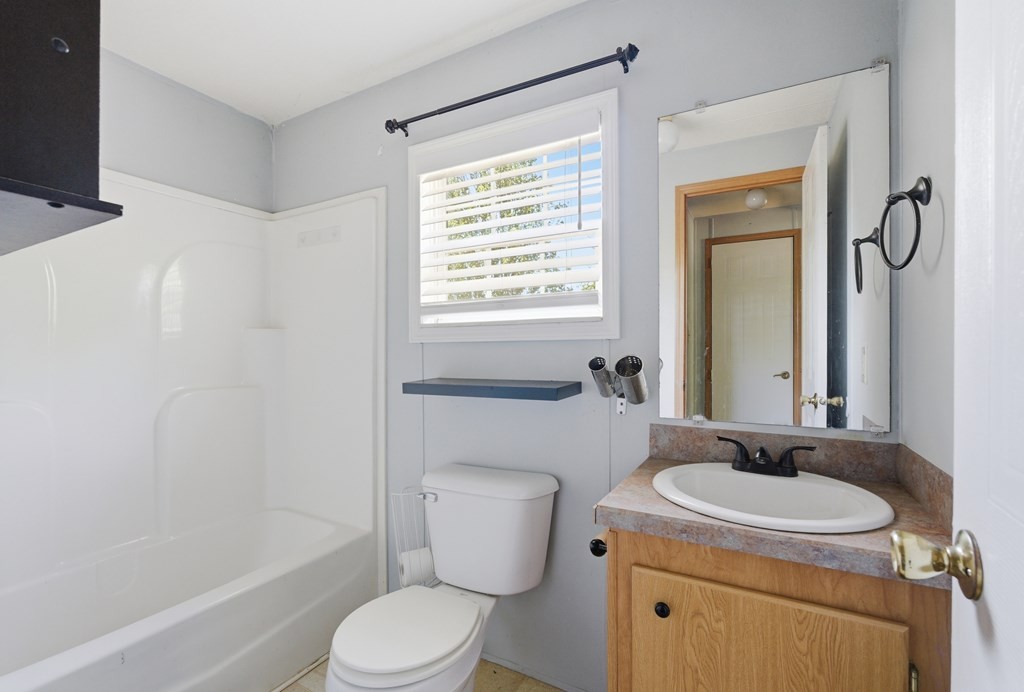 611 Farmer Road Walling, TN 38587 - Photo 21 of 27 a bathroom with a granite countertop toilet sink and mirror
