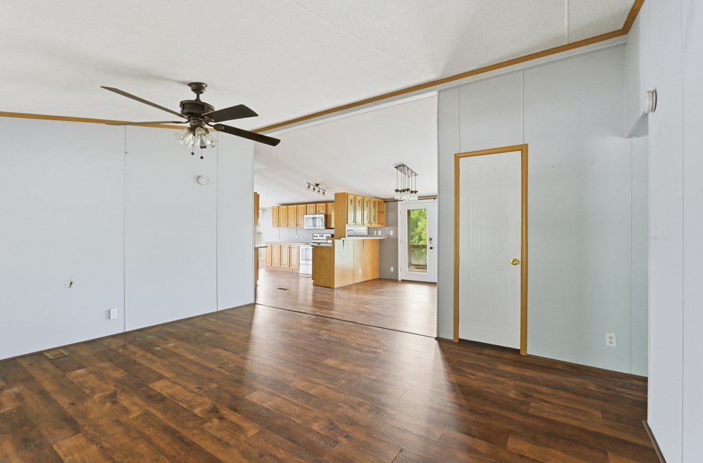 611 Farmer Road Walling, TN 38587 - Photo 9 of 27 a view of a big room with wooden floor and a ceiling fan