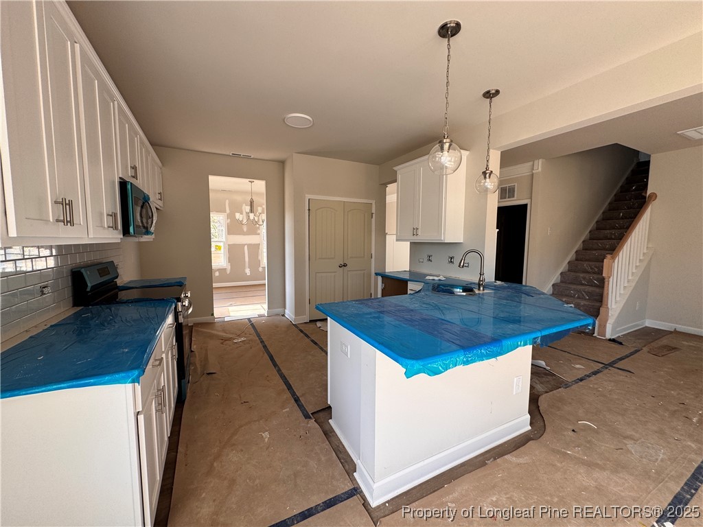 302 Elijah Way Vass, NC 28394 - Photo 11 of 28 a kitchen with stainless steel appliances granite countertop a sink a stove and a wooden floors