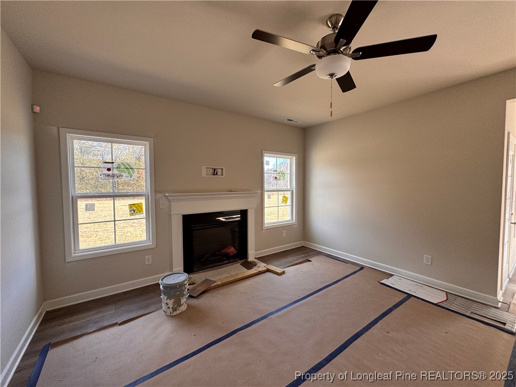 302 Elijah Way Vass, NC 28394 - Photo 12 of 28 a living room with a fireplace furniture a ceiling fan and a window