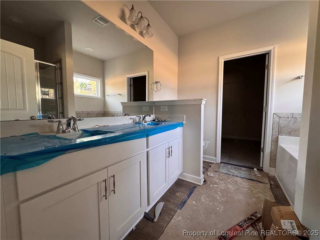 302 Elijah Way Vass, NC 28394 - Photo 14 of 28 a spacious bathroom with a double vanity sink and mirror