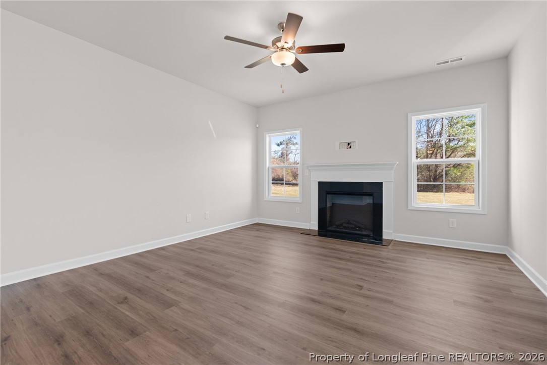 302 Elijah Way Vass, NC 28394 - Photo 29 of 44 a view of empty room with wooden floor and fireplace