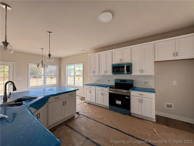 a kitchen with kitchen island granite countertop a sink stainless steel appliances and cabinets