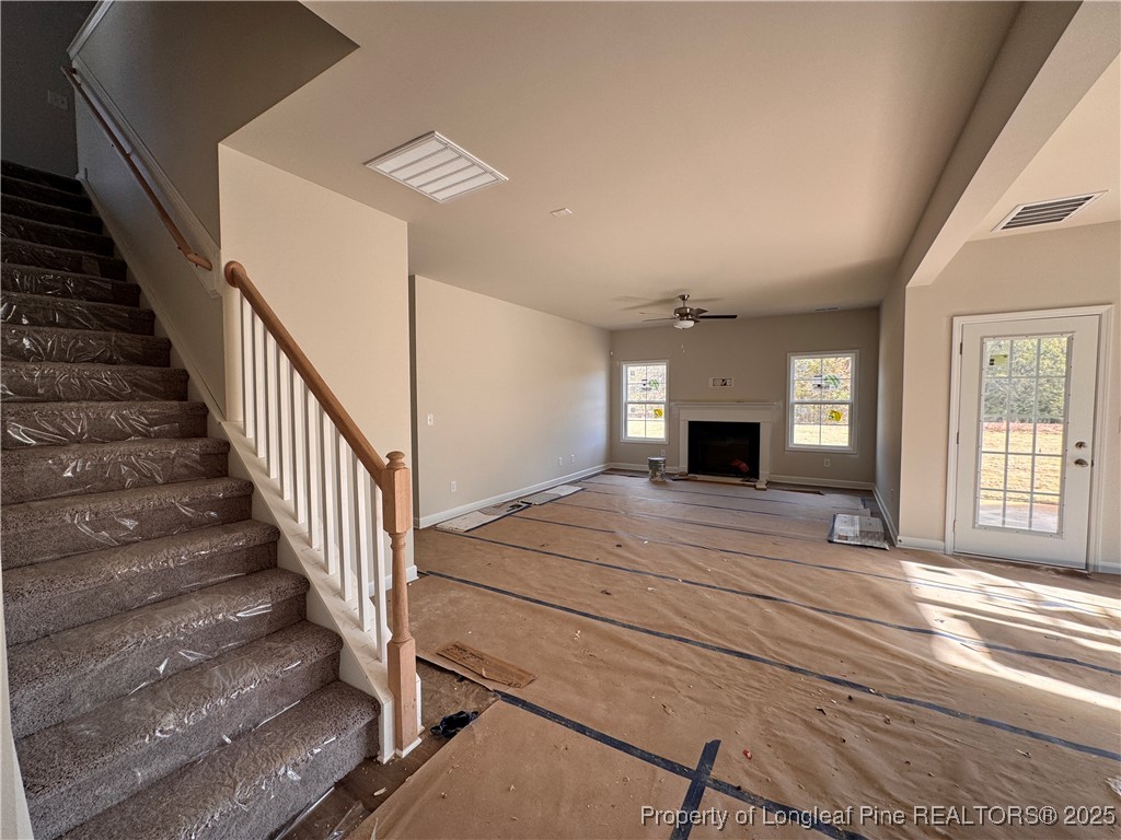 302 Elijah Way Vass, NC 28394 - Photo 9 of 28 a view of a livingroom with wooden floor and staircase