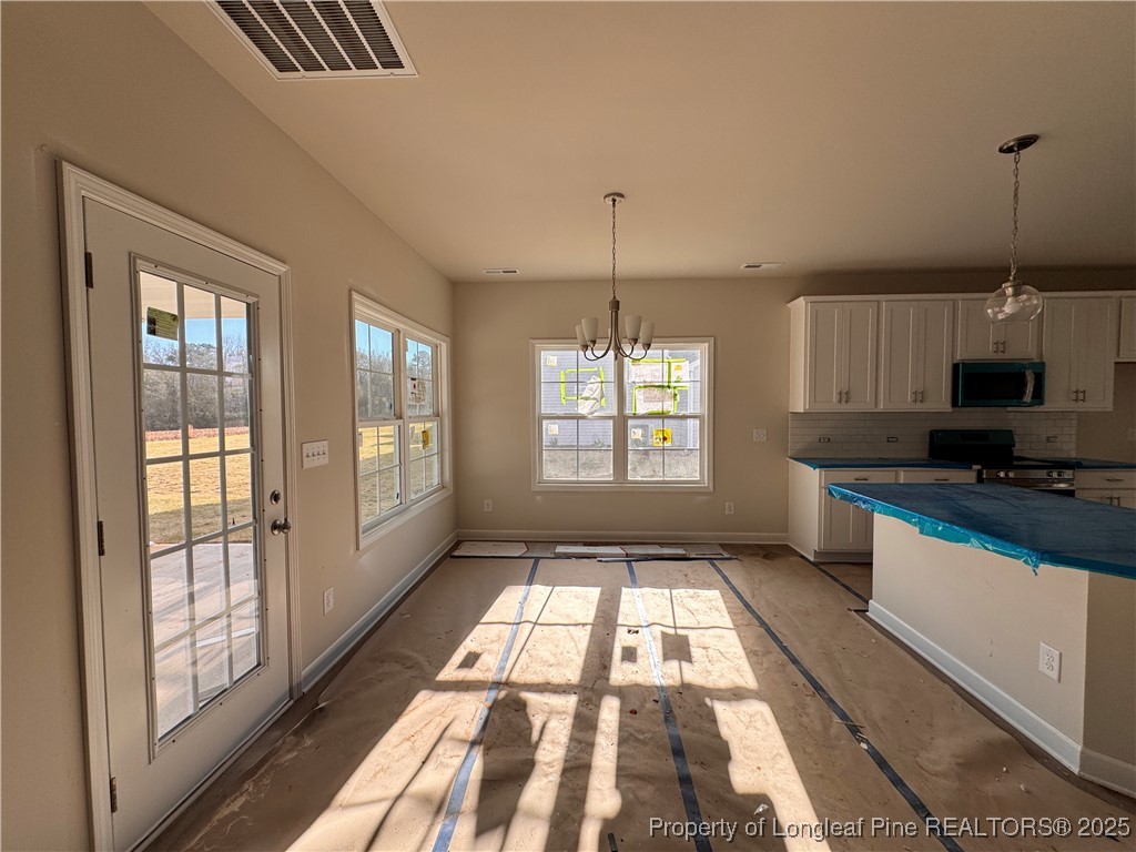 302 Elijah Way Vass, NC 28394 - Photo 10 of 28 a kitchen with granite countertop a stove a sink and a chandelier
