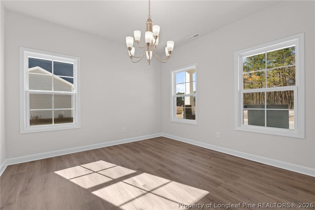 302 Elijah Way Vass, NC 28394 - Photo 10 of 44 a view of an empty room with a window and wooden floor