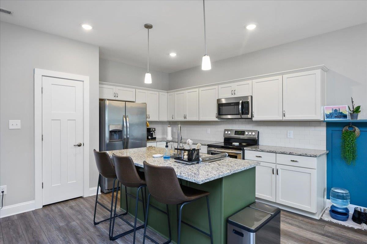 212 North Allen Road Wake Forest, NC 27587 - Photo 16 of 28 a kitchen with a dining table chairs refrigerator and microwave