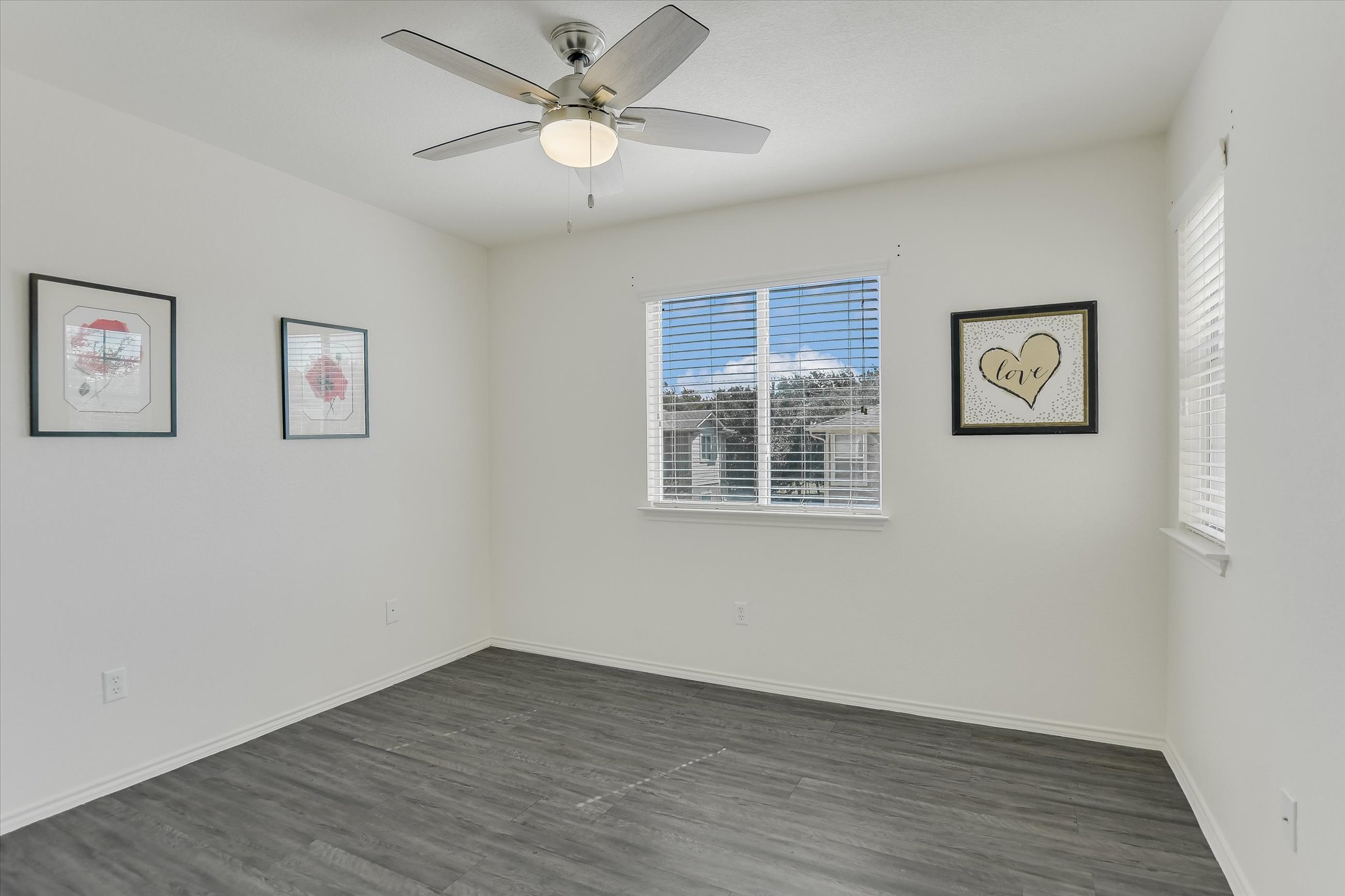809 Sebastian Bend, Unit B Pflugerville, TX 78660 - Photo 19 of 34 a view of an empty room with wooden floor and a ceiling fan