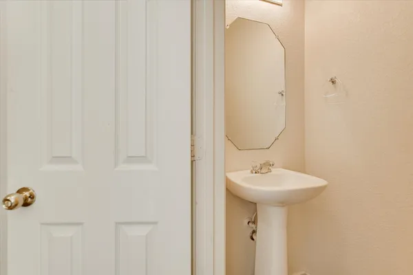 a view of an empty room with wooden floor and a ceiling fan