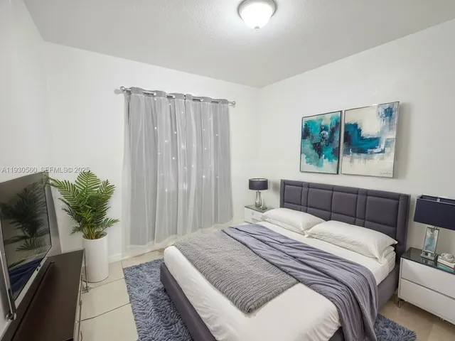 a bedroom with a large bed and a potted plant