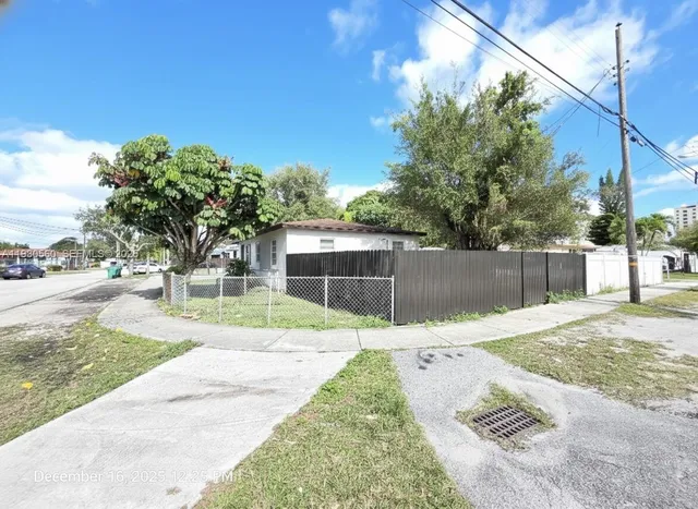 a white house with tree in front of it