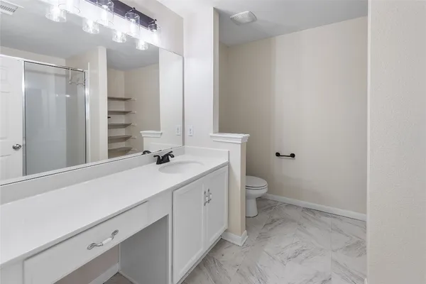 a bathroom with a sink a toilet and shower