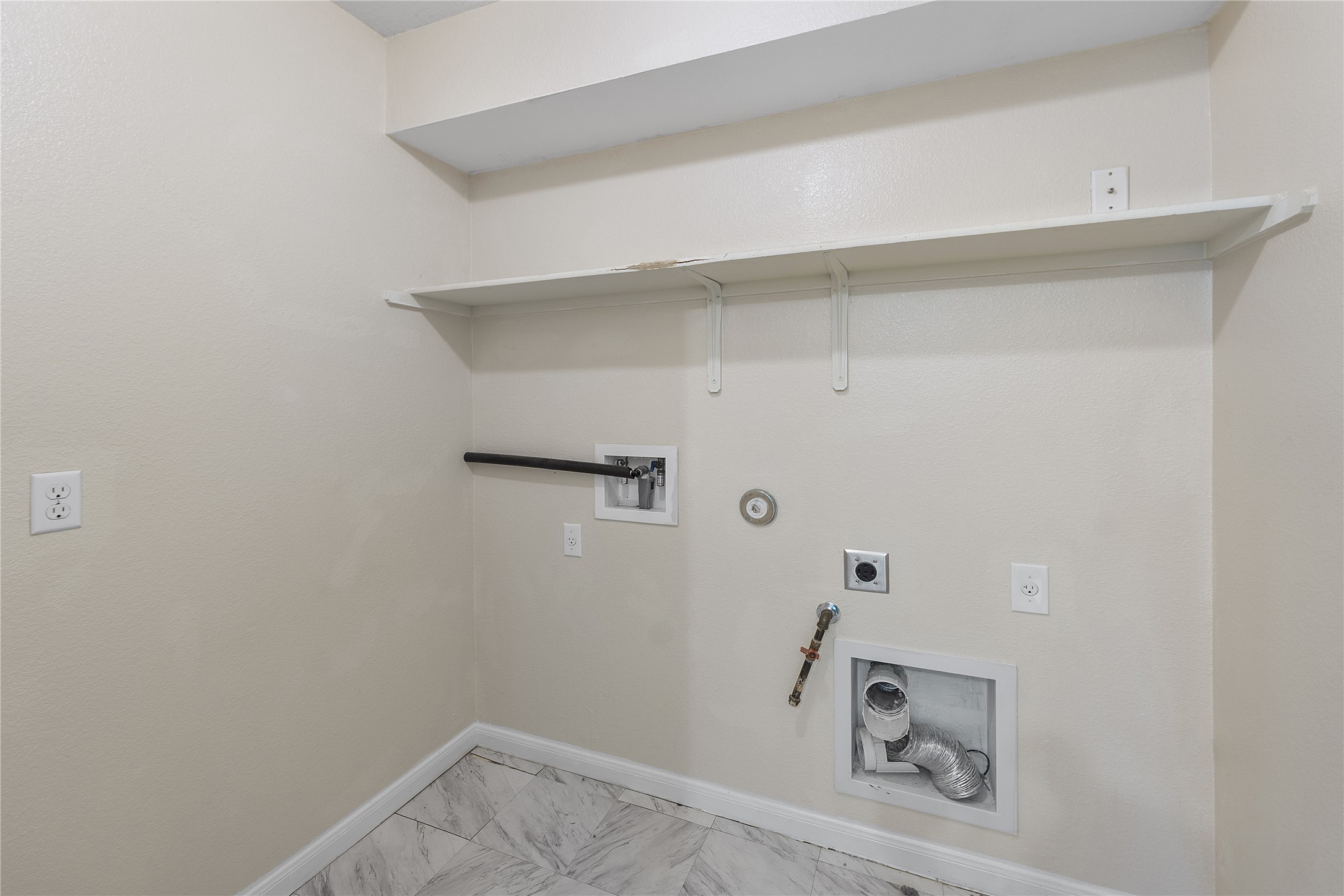 18436 Weatherby Lane Elgin, TX 78621 - Photo 12 of 23 Washroom featuring gas dryer hookup, washer hookup, electric dryer hookup, and light marble finish floors