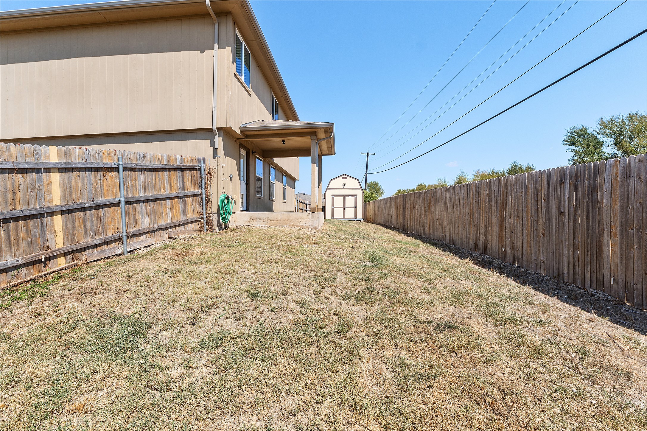 18436 Weatherby Lane Elgin, TX 78621 - Photo 23 of 23 Fenced backyard featuring a storage shed and a patio