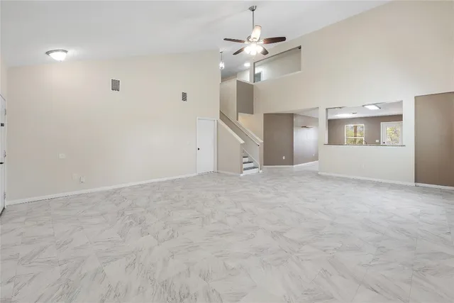 a view of an empty room with a chandelier fan