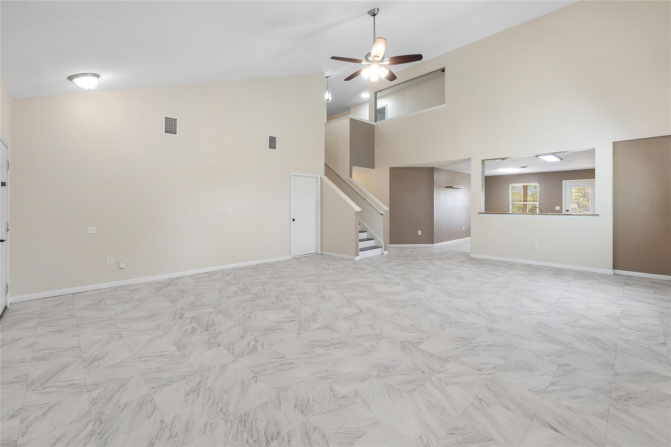 18436 Weatherby Lane Elgin, TX 78621 - Photo 3 of 23 Unfurnished living room featuring high vaulted ceiling, a ceiling fan, and stairway