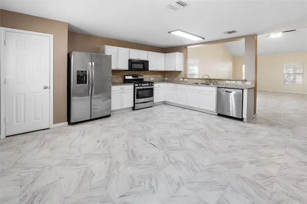 a kitchen with stainless steel appliances a refrigerator sink and microwave