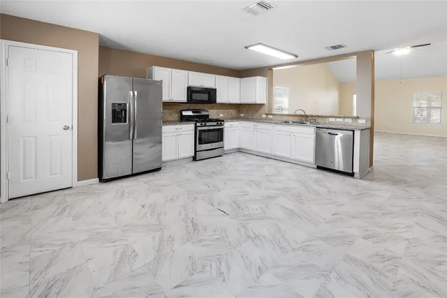 a kitchen with stainless steel appliances a refrigerator sink and microwave