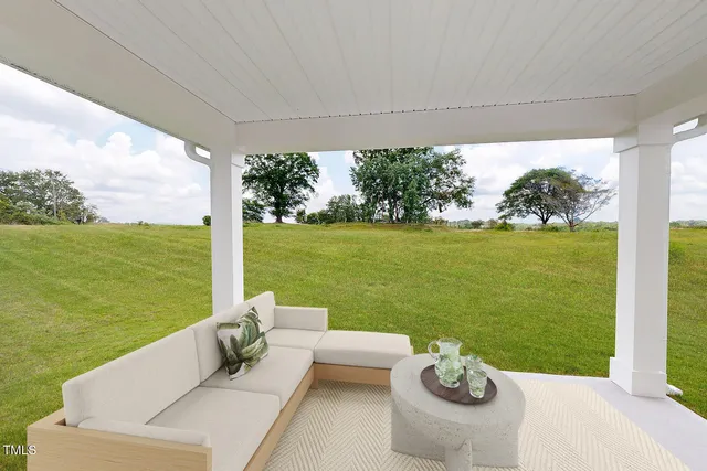 a view of a patio with lawn chairs plants and ocean view