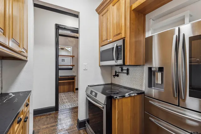 a kitchen with stainless steel appliances granite countertop a refrigerator stove and sink