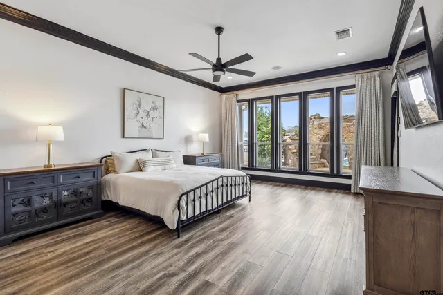 a spacious bedroom with a large bed and a chandelier