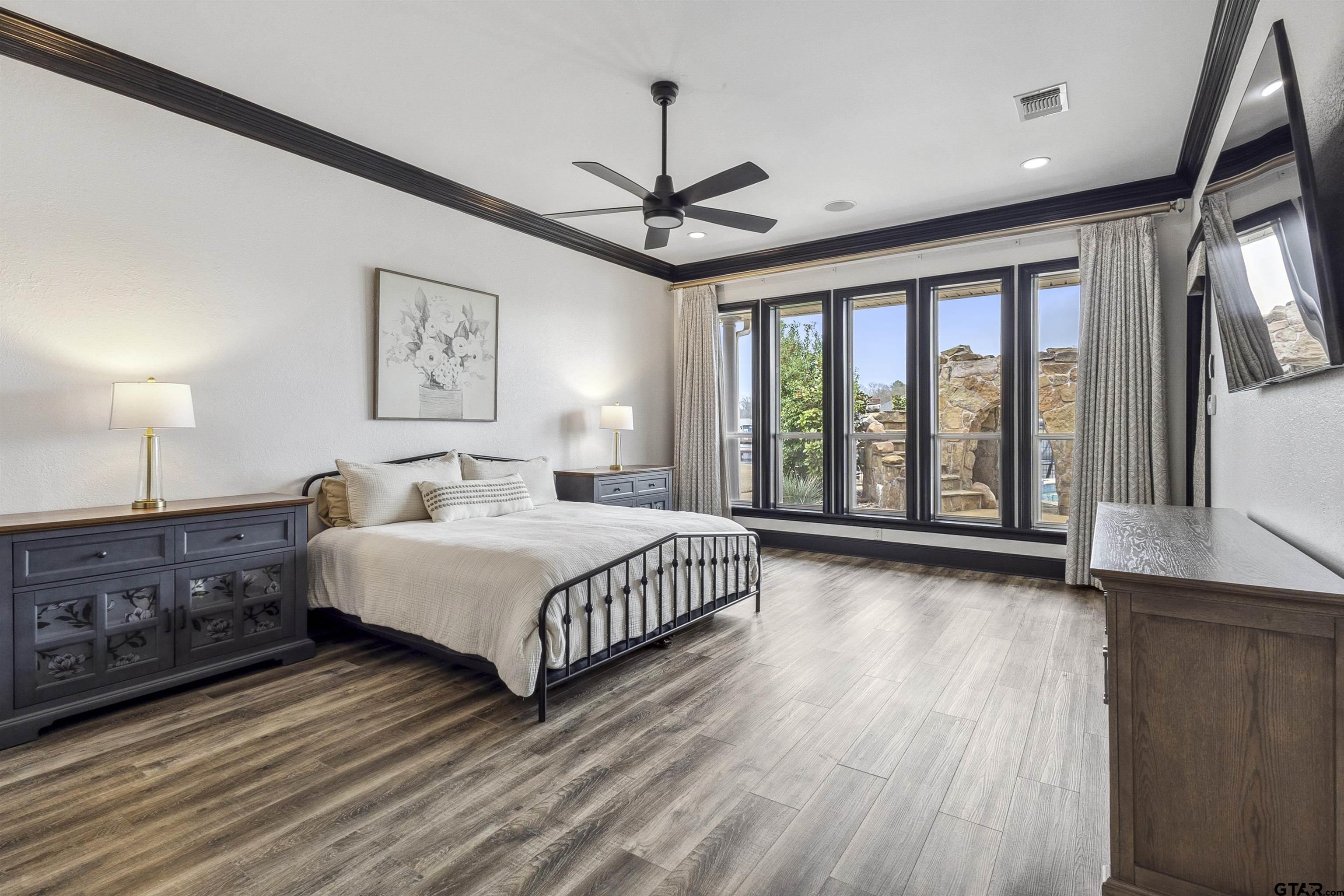 17729 Southpoint Road Whitehouse, TX 75791 - Photo 21 of 48 a spacious bedroom with a large bed and a chandelier