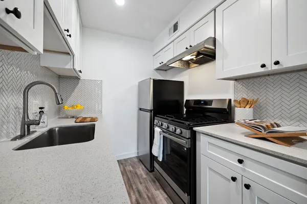 a kitchen with stainless steel appliances granite countertop a sink stove and refrigerator