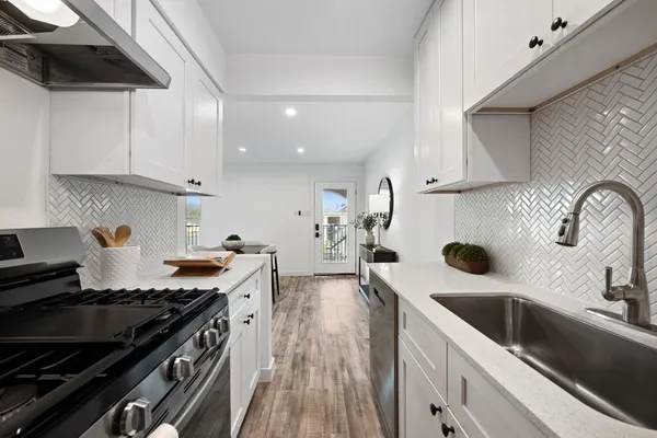 a kitchen with a sink stove top oven and cabinets