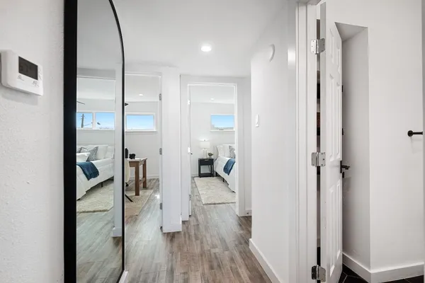 a view of a hallway with wooden floor fireplace and living room