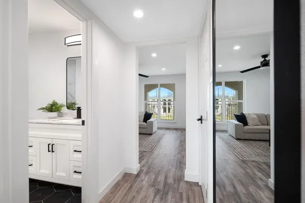a view of a hallway with wooden floor and furniture