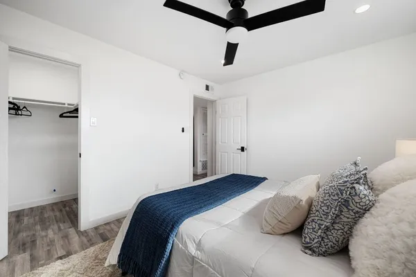 a bedroom with a bed and a ceiling fan