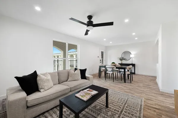 a living room with furniture and a wooden floor