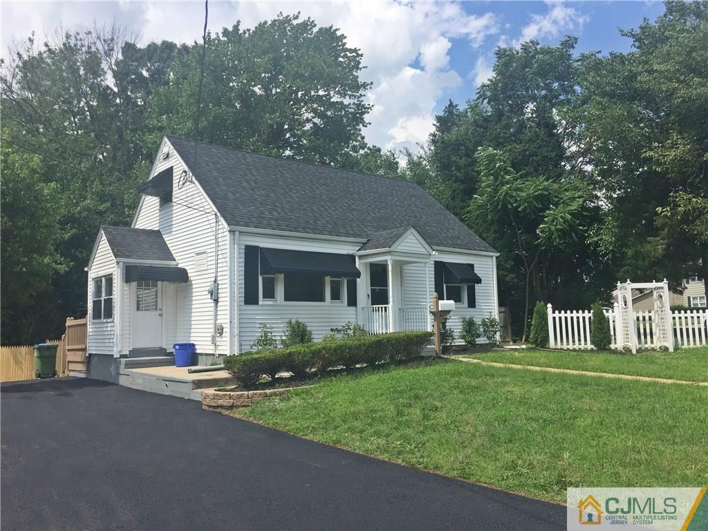 a front view of a house with a garden and trees