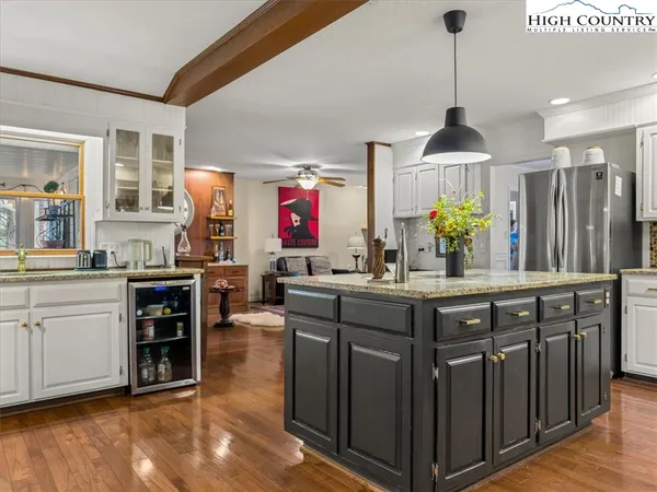 a kitchen with granite countertop a stove chairs and fireplace