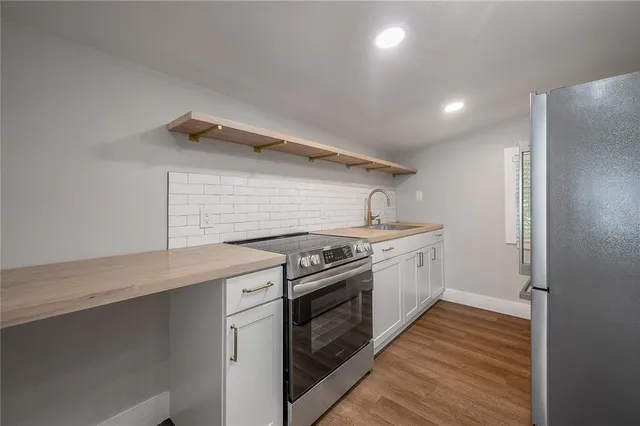 a kitchen with a stove top oven and cabinets