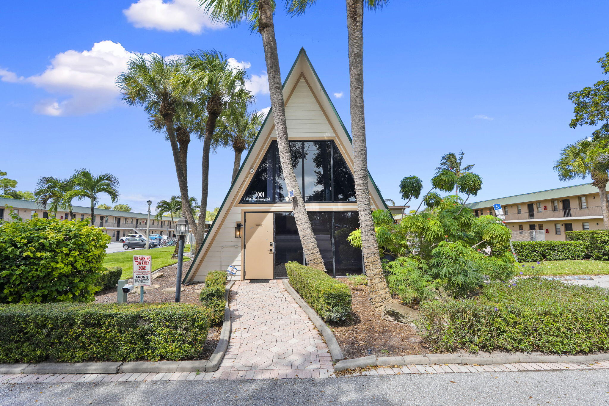 1001 Southeast Monterey Road Stuart, FL 34994 - Photo 2 of 17 a front view of a house with a yard and potted plants