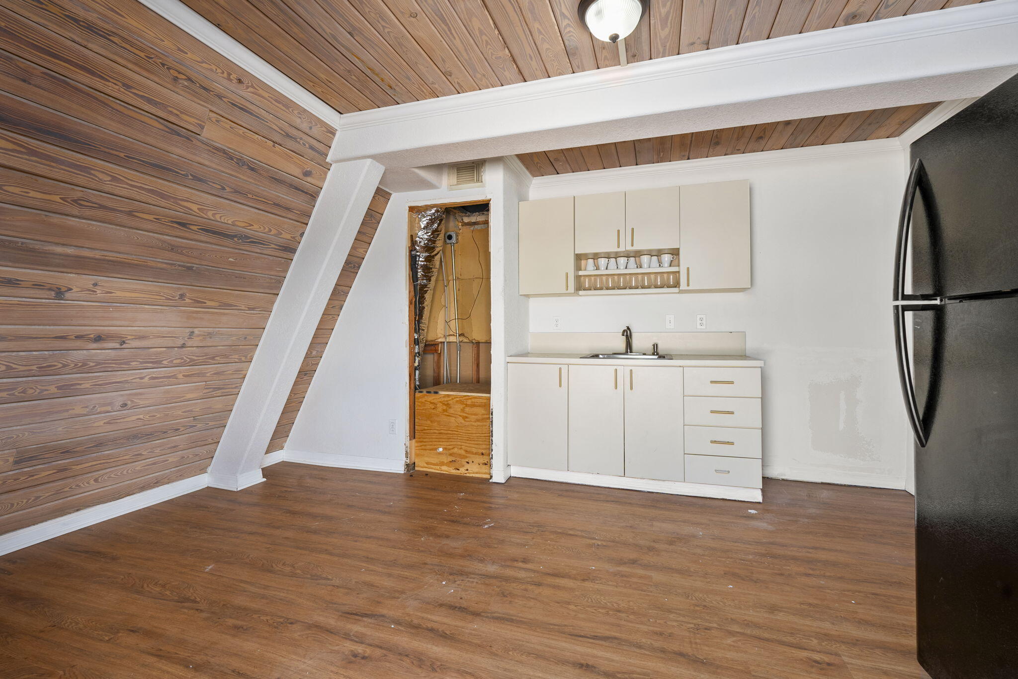 1001 Southeast Monterey Road Stuart, FL 34994 - Photo 7 of 17 a view of a kitchen with refrigerator and wooden floor