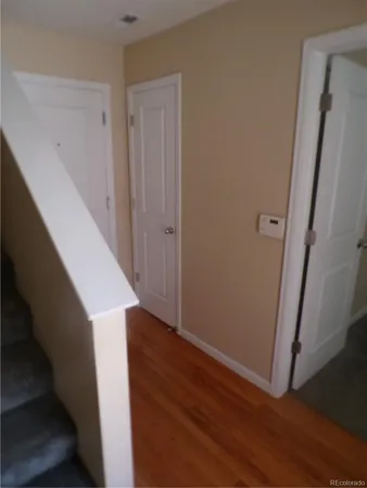 a view of hallway with stairs and wooden floor