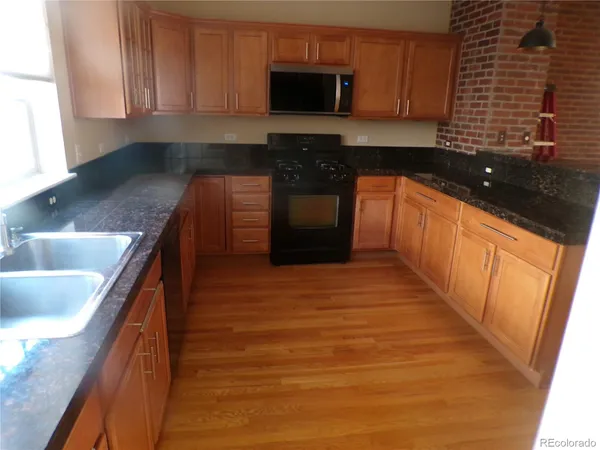 a kitchen with stainless steel appliances granite countertop a sink and a stove