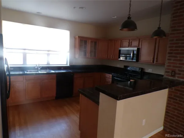 a kitchen with granite countertop a sink a stove and cabinets