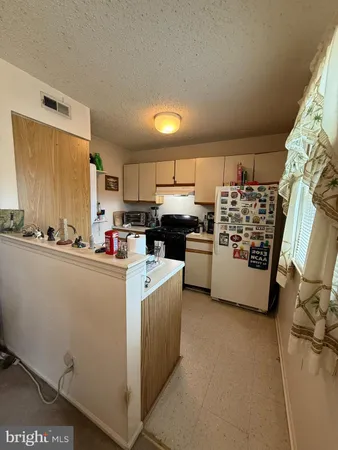 a kitchen with cabinets and white stainless steel appliances