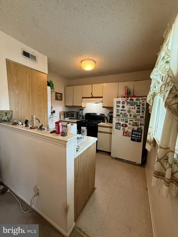 a kitchen with cabinets and white stainless steel appliances