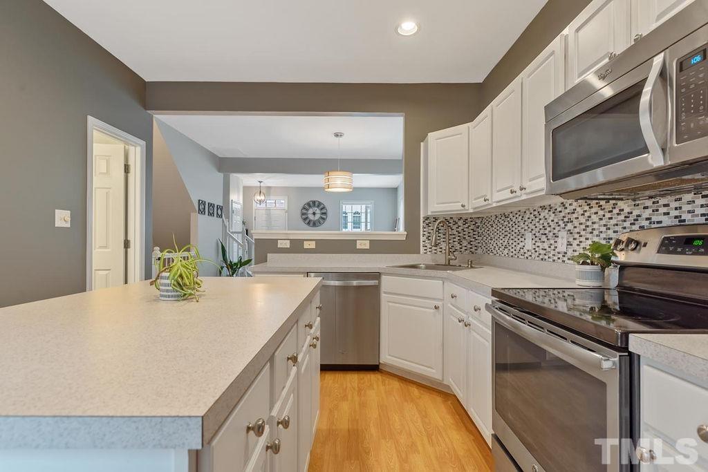4711 Longhill Lane Raleigh, NC 27612 - Photo 11 of 27 a kitchen with stainless steel appliances granite countertop a sink stove and microwave