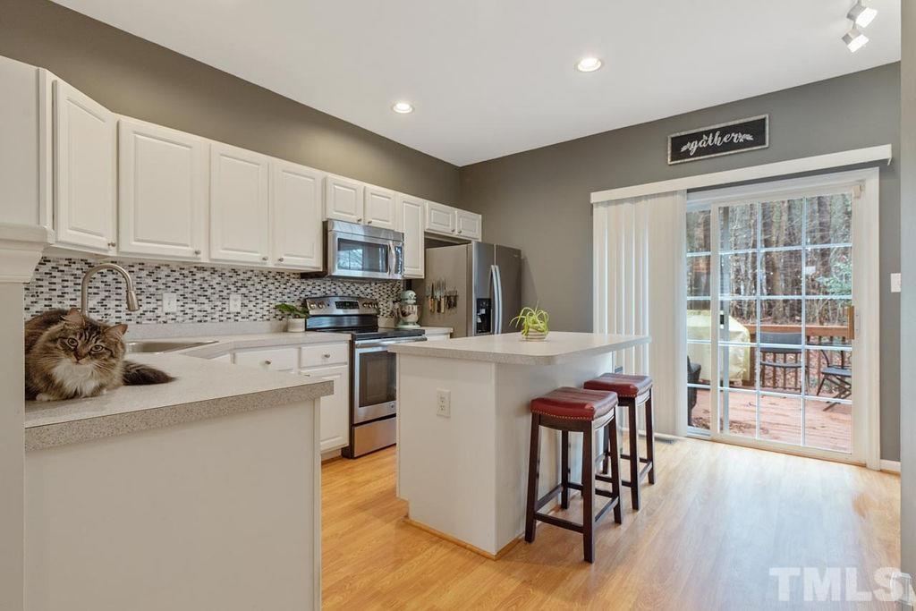 4711 Longhill Lane Raleigh, NC 27612 - Photo 9 of 27 a kitchen with stainless steel appliances granite countertop a stove a sink a microwave and a refrigerator